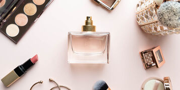 Perfume,Bottle,With,Makeup,Cosmetics,On,Pink,Dressing,Table.,Scent