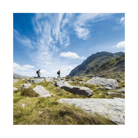 Two Men Walking Across Rocks